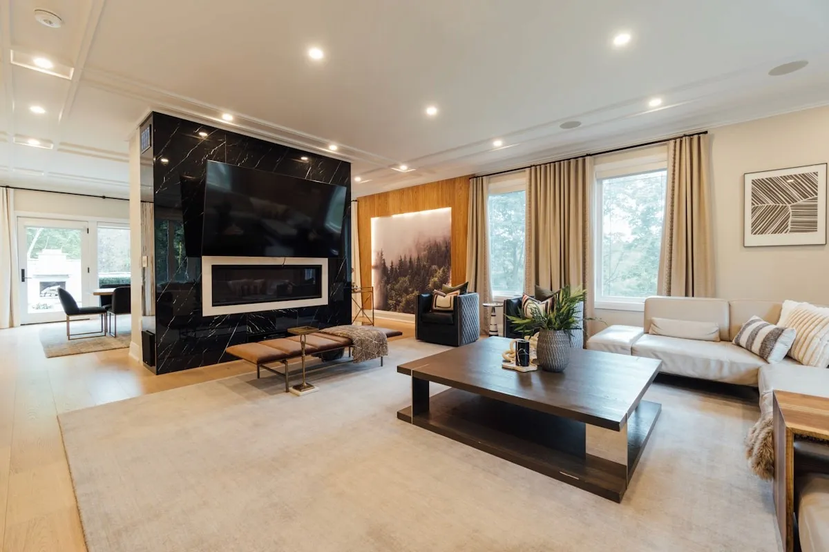 Modern countryside estate living room with a fireplace, broad seating area, and warm neutral finishes